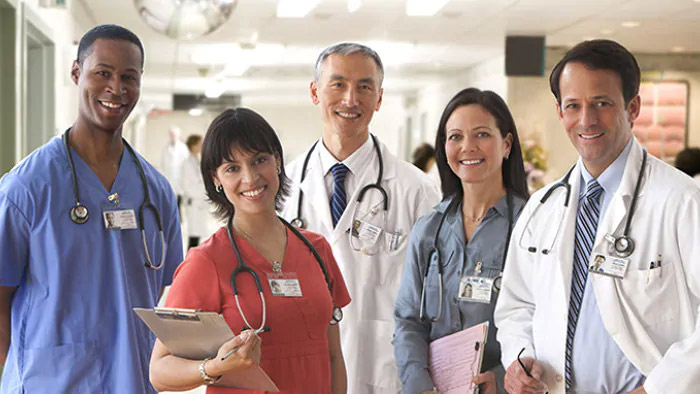 Cinq m&eacute;decins en tenue m&eacute;dicale