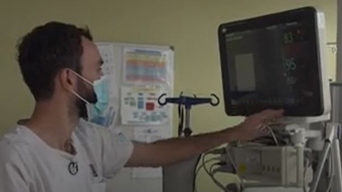 un homme portant un masque et tenant un ordinateur