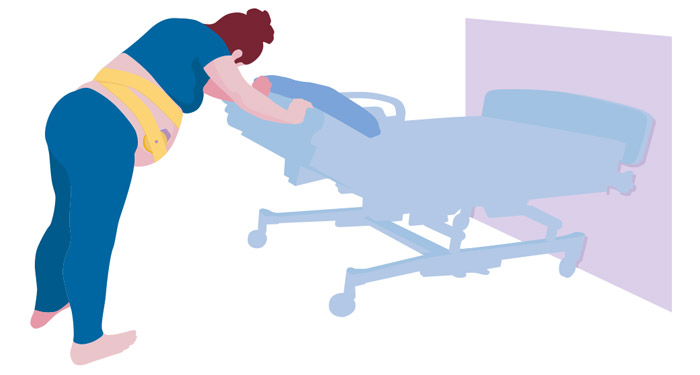 une femme poussant un patient dans un lit d'h&ocirc;pital