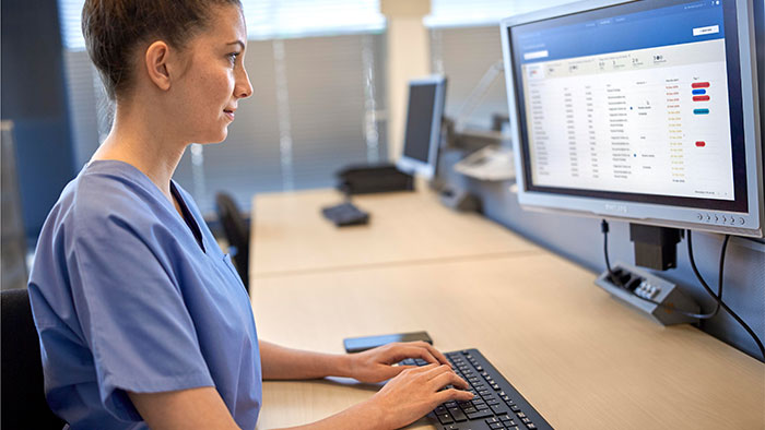 Une clinicienne regarde l&rsquo;&eacute;cran en tapant sur le clavier pour saisir des donn&eacute;es