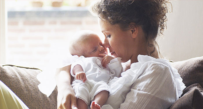 une femme tenant un b&eacute;b&eacute;