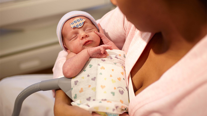 une femme tenant un b&eacute;b&eacute;