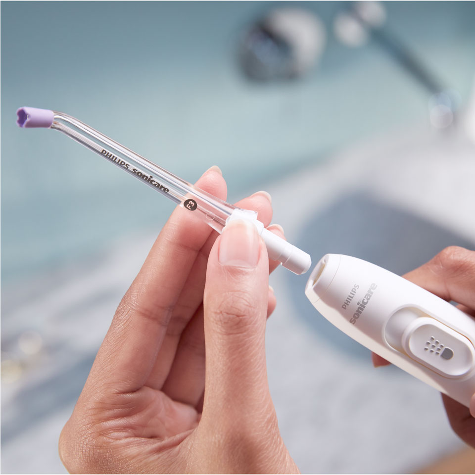 Main fixant une canule Quad&nbsp;Stream sur le Power&nbsp;Flosser