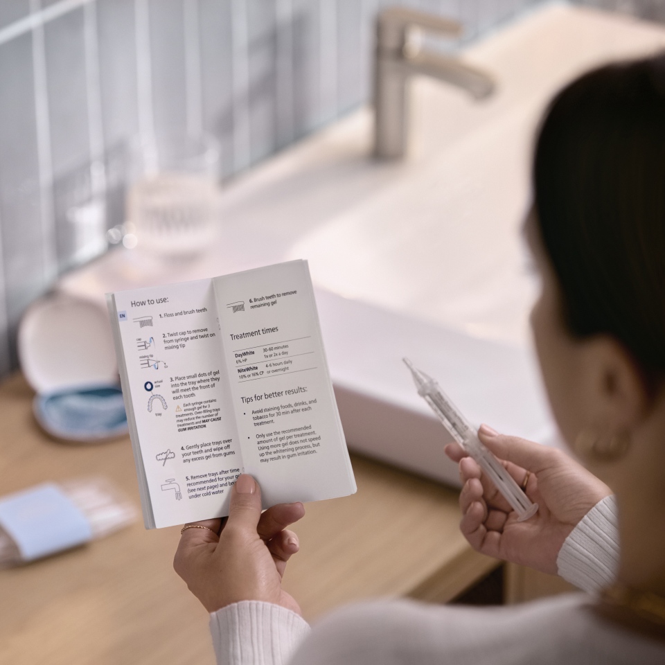 Patient appliquant du gel &eacute;claircissant sur une goutti&egrave;re sur mesure