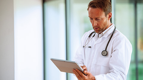 M&eacute;decin regardant une tablette