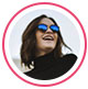 Une image de profil d&rsquo;une consommatrice, une femme portant des lunettes de soleil et qui sourit en regardant au loin.