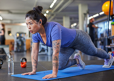Femme faisant activement de l'exercice tout en utilisant les &eacute;couteurs v&eacute;ritablement sans fil Philips A5508