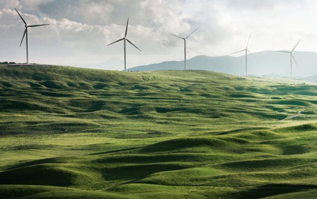 Centrale &eacute;olienne sur des collines, symbolisant les &eacute;nergies renouvelables et le d&eacute;veloppement durable en entreprise.