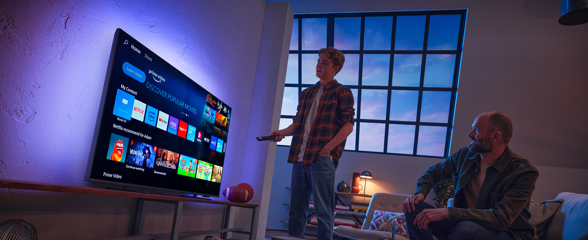 Un homme choisissant une application sur le t&eacute;l&eacute;viseur Philips Smart&nbsp;TV